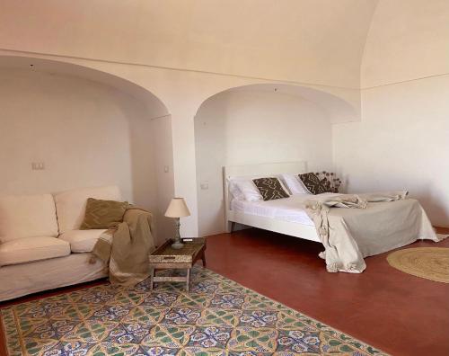 a living room with a bed and a couch at Tenuta Bukkuram in Pantelleria