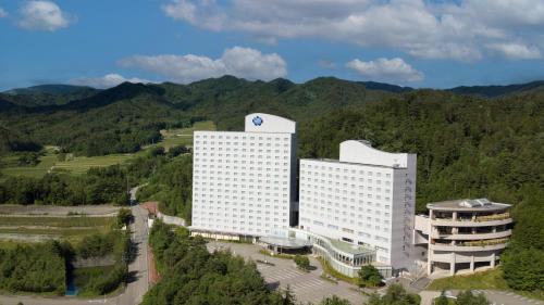 an aerial view of a building with mountains in the background at Hotel Associa Takayama Resort in Takayama