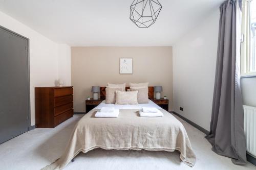 a bedroom with a large bed with two towels on it at The Wapping Villas in London