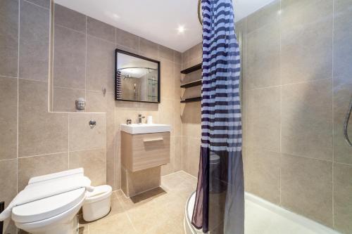 y baño con aseo, lavabo y ducha. en The Wapping Villas, en Londres