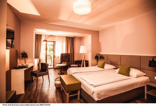 ein Hotelzimmer mit einem Bett, einem Schreibtisch und Stühlen in der Unterkunft Simon - das Vitalhotel in Bad Tatzmannsdorf