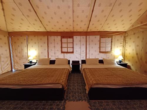 dwa łóżka siedzące w pokoju z dwoma lampami w obiekcie Shivir Aranya - Wilderness Resort w mieście Alwar