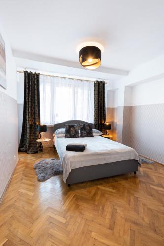 sypialnia z dużym łóżkiem i drewnianą podłogą w obiekcie ClickTheFlat Muranów Apart Rooms w Warszawie
