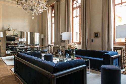 a living room with blue couches and a table at Nolinski Venezia - Evok Collection in Venice