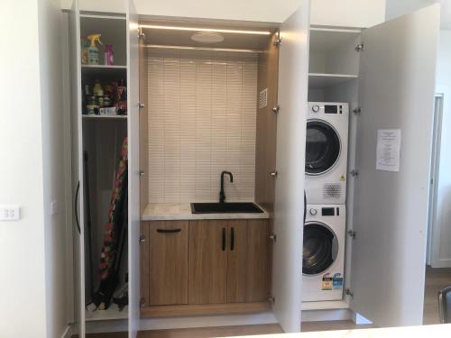 a laundry room with a sink and a washer and dryer at Luxe & Superior 2BR Villas Patio Free Parking & Wifi in Launceston