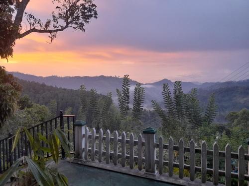 a white picket fence with a view of the mountains at Himansa Homestay in Ella