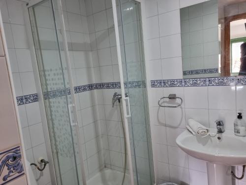 a bathroom with a shower and a sink at NcantadaROOMS in Tragacete