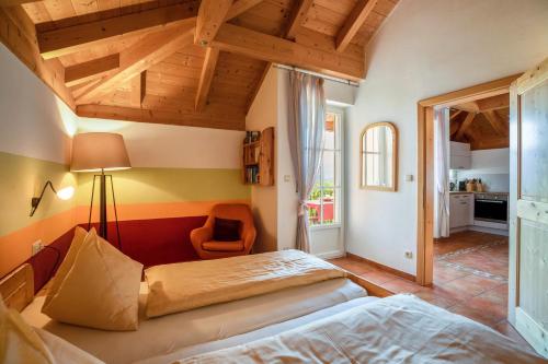 a bedroom with two beds and a chair at Weingut Lieselehof Apt Rosengarten in Caldaro
