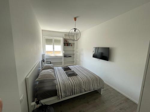 1 dormitorio pequeño con 1 cama y TV en Ca Re Rovereto en Pordenone