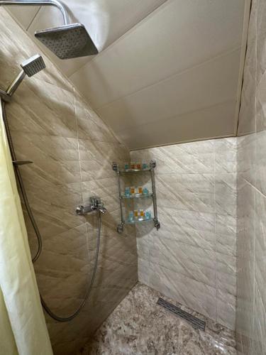 y baño con ducha con cabezal de ducha. en Stumari Apartaments, en Tiflis