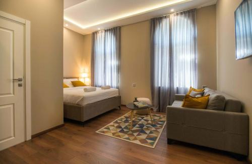 ein Wohnzimmer mit einem Sofa und einem Bett sowie ein Zimmer mit einem Sofa in der Unterkunft Hotel Nacional in Bosanska Gradiška