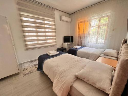 a hotel room with two beds and a television at DALAMAN 2 ODALI DAİRE in Dalaman