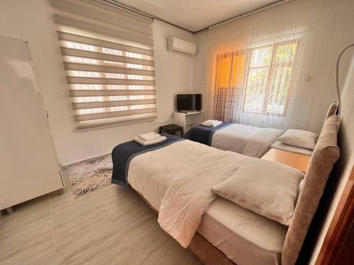 a bedroom with two beds and a television in it at DALAMAN 2 ODALI DAİRE in Dalaman