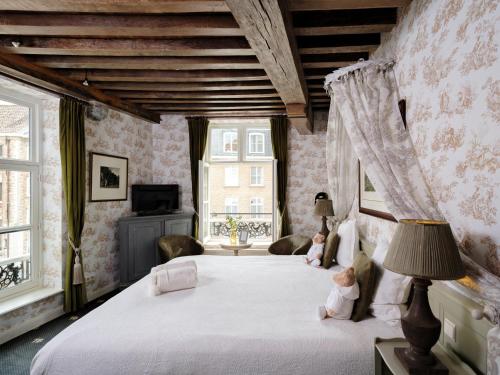 a bedroom with two dolls sitting on a bed at Hotel Ter Brughe by CW Hotel Collection in Bruges