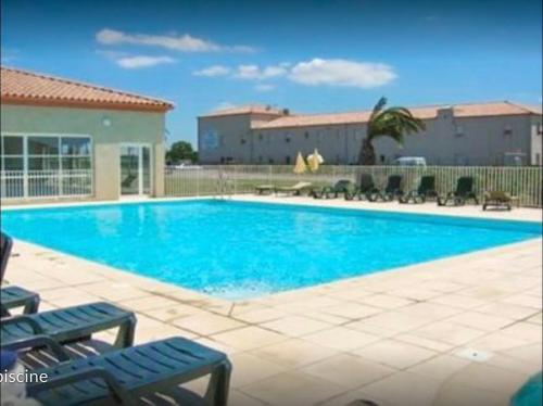 una gran piscina con agua azul y sillas en Agréable maisonnette de 45m2, en Gallargues-le-Montueux