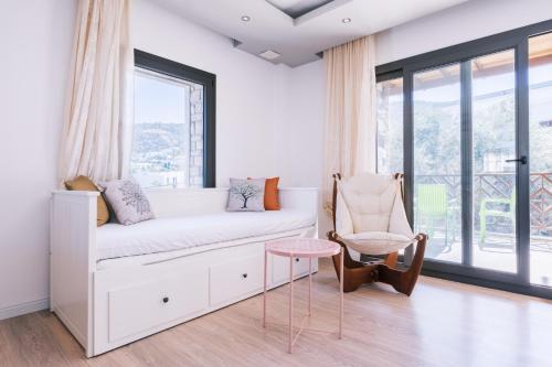 a white room with a bed and a chair at Chic Flat w Balcony 3 min to Beach in Bodrum in Bodrum City