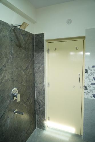 a shower with a glass door in a bathroom at 5 STAR GRAND- PREMIUM in Shamshabad