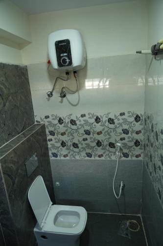 a bathroom with a toilet and a camera on the wall at 5 STAR GRAND- PREMIUM in Shamshabad