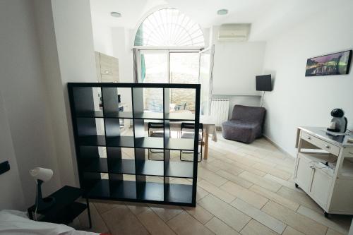 een woonkamer met een glazen boekenplank en een tafel bij Amalia Apartment Via La Farina in Florence