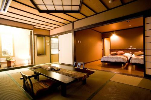 Oyado Kinkiyu Annex SUIKAZURA في Teshikaga: غرفة نوم بسرير وطاولة في غرفة