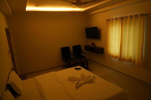 a bedroom with a white bed and a window at 5 STAR GRAND- PREMIUM in Shamshabad