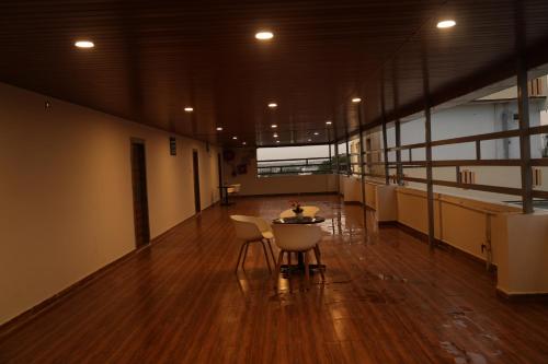a hallway with a table and chairs in a building at 5 STAR GRAND- PREMIUM in Shamshabad