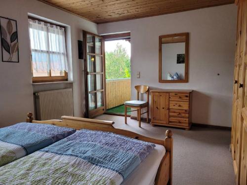 1 dormitorio con cama, espejo y silla en Gästehaus Josefine en Lam