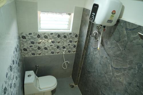 a bathroom with a shower and a toilet and a window at 5 STAR GRAND- PREMIUM in Shamshabad