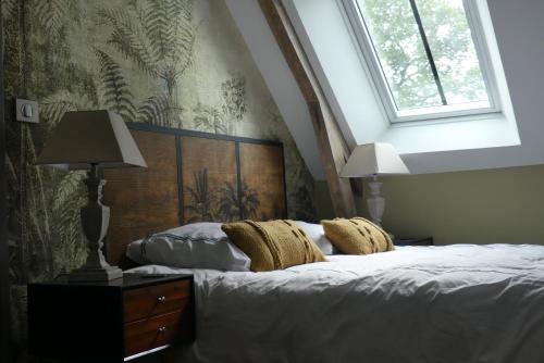um quarto com uma cama grande e uma janela em Le Clos Luly em Neulliac