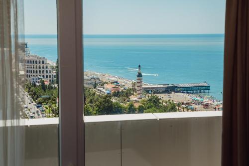 uma vista a partir de uma janela de uma cidade e do oceano em Alliance Palace Aparthotel em Batumi