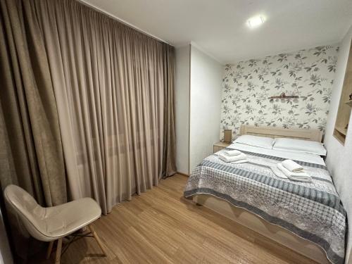 1 dormitorio con 1 cama y 1 silla en Stumari Apartaments, en Tiflis