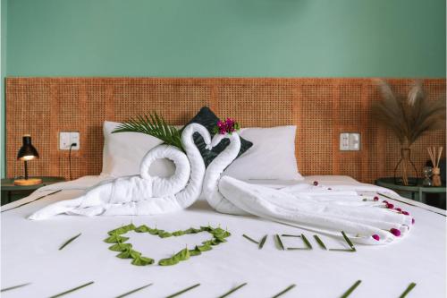 two swansrendered to look like they are kissing on a bed at Leaf Hotel Phu Quoc in Phu Quoc
