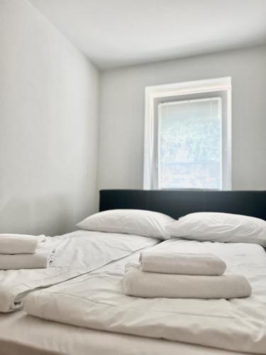 a bed with white sheets and a window in a room at ZARA APARTMENTS in Koper