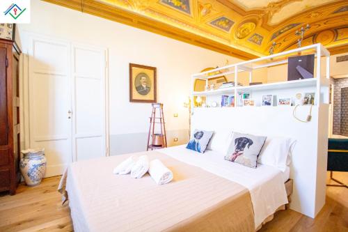 Schlafzimmer mit einem großen weißen Bett und einer Decke in der Unterkunft Appartamento Orsini in Pisa