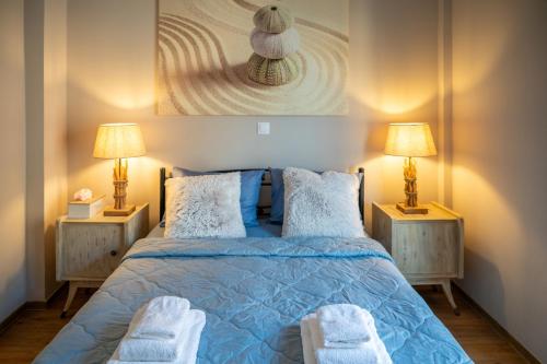 a bedroom with a blue bed with two lamps at Acropolis Terrace View Apartment in Athens