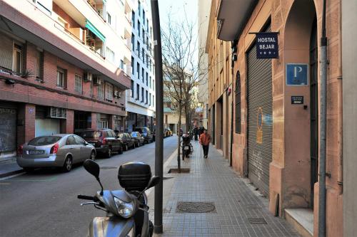 una motocicleta estacionada al lado de una calle de la ciudad en Hostal Bejar en Barcelona