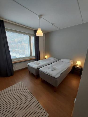 - 2 lits dans une chambre avec une grande fenêtre dans l'établissement Kotimaailma - Tyylikäs kolmio Tikkurilassa, à Vantaa