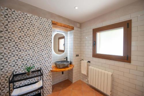 a bathroom with a sink and a mirror at Casa Rural Cal Martí in El Pla de Manlleu