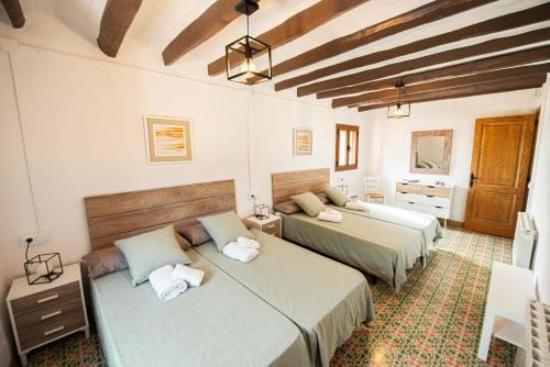 1 dormitorio con 2 camas en una habitación en Casa Rural Cal Martí en El Pla de Manlleu