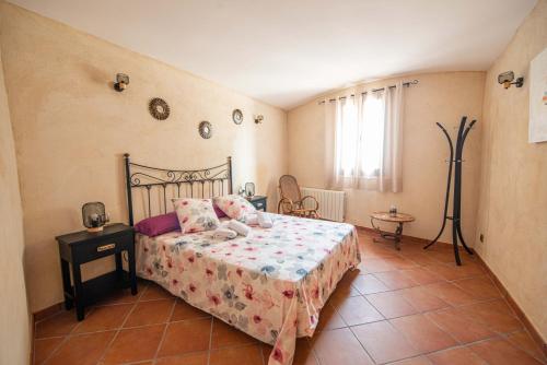 a bedroom with a bed and a table and a window at Casa Rural Cal Martí in El Pla de Manlleu