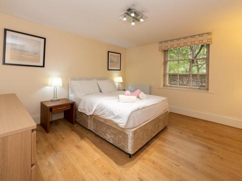 een slaapkamer met een bed met een roze knuffeldier erop bij Pass the Keys Charming 3 BDR Home close to Reading Town Centre in Reading