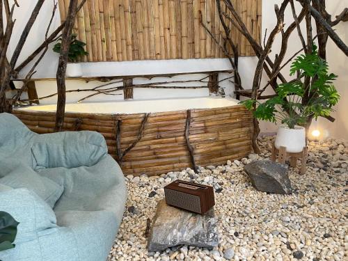 ein Wohnzimmer mit einem Sofa und einer Badewanne in der Unterkunft กาลเวลา เกาะสีชัง in Ban Tha Thewawong