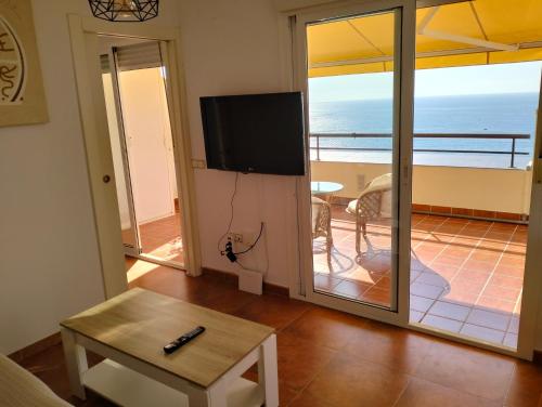 ein Wohnzimmer mit einem TV und Meerblick in der Unterkunft Fabuloso Atico con vistas al mar in Carboneras
