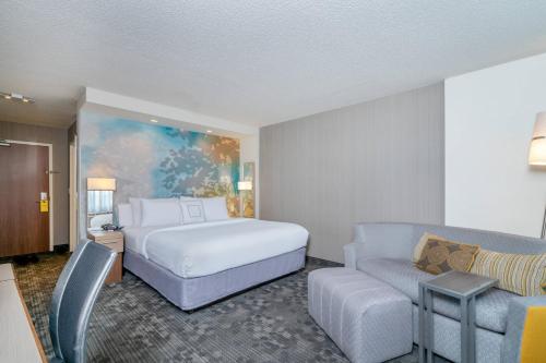 um quarto de hotel com uma cama e um sofá em Courtyard by Marriott Wilkes-Barre Arena em Wilkes-Barre
