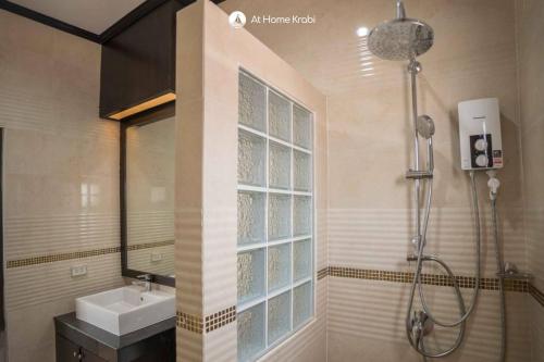 a bathroom with a sink and a shower with a window at Nadia's Ao Nang Pool Villa in Ban Chong Phli