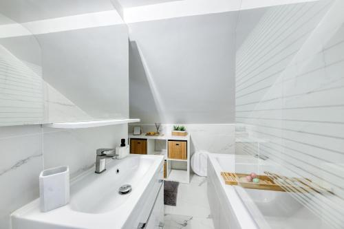 a white bathroom with a tub and a sink at Bundle Famille Max - 12 personnes in La Courneuve