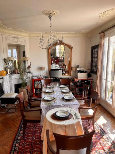 une salle à manger avec une longue table et des chaises dans l'établissement Paris 2 bedrooms chic apartment 18th district, à Paris