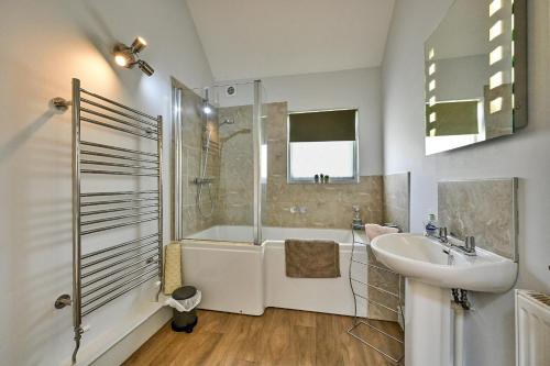 a bathroom with a tub and a sink and a shower at Finest Retreats - The Burrow at Conygre Farm in Pewsey