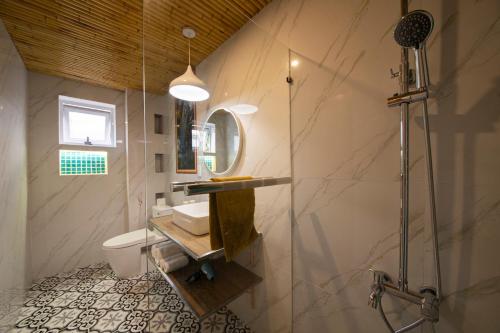 a bathroom with a shower and a sink and a mirror at Hoi An Golden Bamboo An Bang Beach Villa & Spa in Hoi An