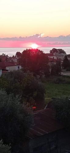 a sunset over the ocean with the sun in the sky at ANASTASIA ROOMS in Stratónion